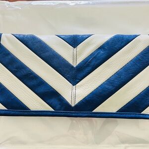 Blue and cream clutch with vibrant yellow interior lining. Button closure
